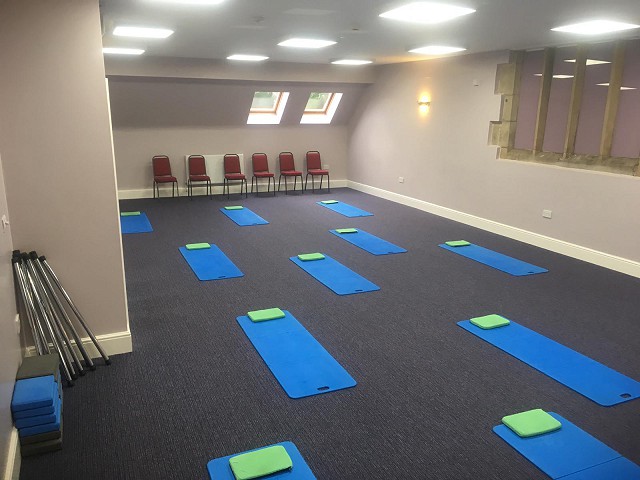 a series of exercise mats laid out neatly in a spacious, well-lit room.